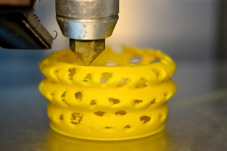 3d printer printing objects yellow form closeup. Modern technical 3D printing.の写真素材