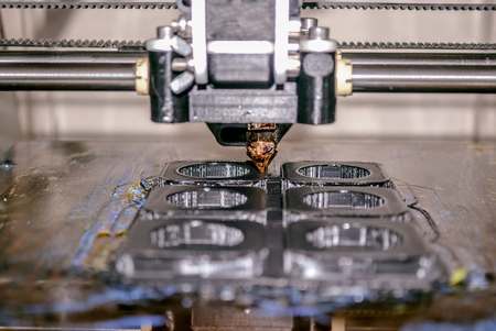 Modern 3D printer printing figure close-up macro. Automatic three dimensional 3d printer performs plastic modeling in laboratory.の写真素材