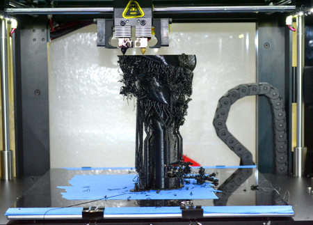 3d printer printing black shapes close-up. Image of automatic three dimensional 3d printer performs plastic modeling in laboratory.の写真素材