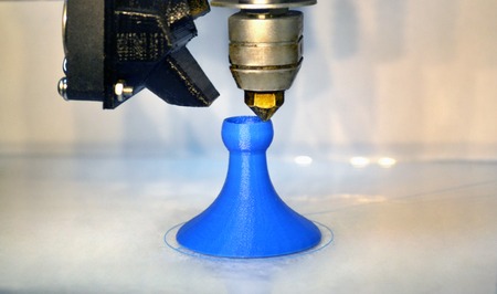 Modern 3D printer printing figure close-up macro.Automatic three dimensional 3d printer performs plastic blue colors modeling in laboratory. 3d-printing processing with white backgroundの写真素材