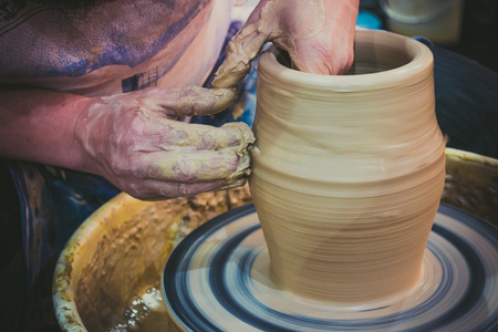 The potter molds clay jug pot closeup. Workshop on sculpt white clay closeup. Dirty hands in the clay. Making ceramic products . Artistic creative.の写真素材