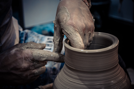 The potter molds clay jug pot closeup. Workshop on sculpt white clay closeup. Dirty hands in the clay. Making ceramic products . Artistic creative.の写真素材