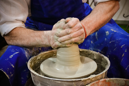 The potter molds clay jug pot closeup. Workshop on sculpt white clay closeup. Dirty hands in the clay. Making ceramic products . Artistic creative.の写真素材