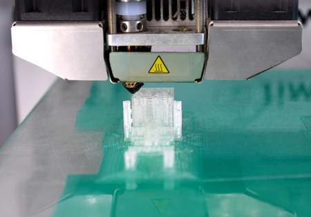 3D printer working and creating an object from the hot molten plastic close-up. Automatic three...
