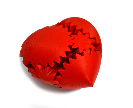 Objects printed by 3d printer Isolated on white background. Bright colorful object. Heart of red color, several parts. Automatic three dimensional 3d printer performs plastic modeling in laboratory.の写真素材