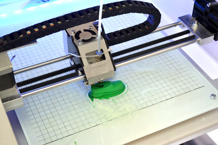 3D printer prints the form of molten plastic green close-up. Automatic three dimensional 3d printer performs plastic modeling in laboratory. Progressive modern additive technologyの写真素材