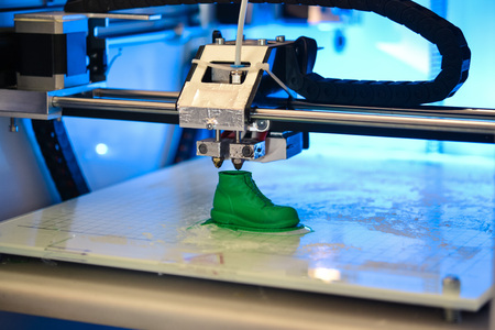 3D printer prints the form of molten plastic green close-up. Automatic three dimensional 3d printer performs plastic modeling in laboratory. Progressive modern additive technologyの写真素材