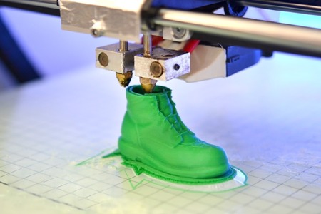 3D printer prints the form of molten plastic green close-up. Automatic three dimensional 3d printer performs plastic modeling in laboratory. Progressive modern additive technologyの写真素材