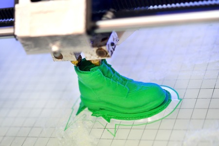 3D printer prints the form of molten plastic green close-up. Automatic three dimensional 3d printer performs plastic modeling in laboratory. Progressive modern additive technologyの写真素材
