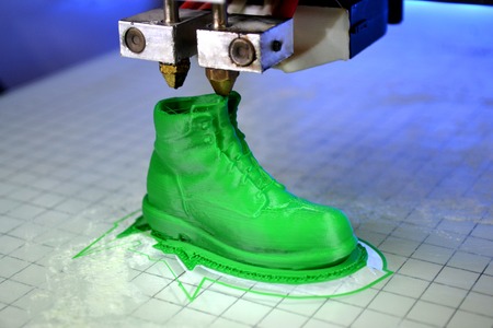 3D printer prints the form of molten plastic green close-up. Automatic three dimensional 3d printer performs plastic modeling in laboratory. Progressive modern additive technologyの写真素材
