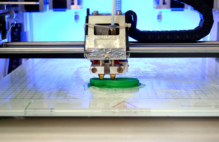 3D printer prints the form of molten plastic green close-up. Automatic three dimensional 3d printer performs plastic modeling in laboratory. Progressive modern additive technologyの写真素材