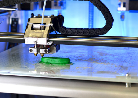 3D printer prints the form of molten plastic green close-up. Automatic three dimensional 3d printer performs plastic modeling in laboratory. Progressive modern additive technologyの写真素材