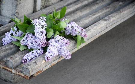 bouquet of flowers of purple lilac lies on an old vintage wooden surface