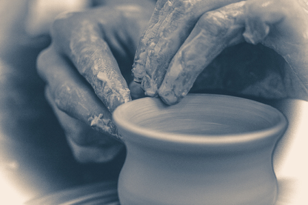 Old vintage photo. The potter molds clay jug pot closeup.の写真素材