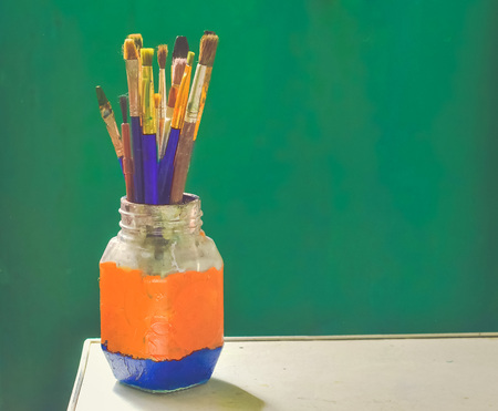 Brushes for painting stand with bristles up in a glassの写真素材