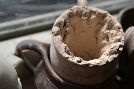 Mug with dried clay close-up by the windowの写真素材
