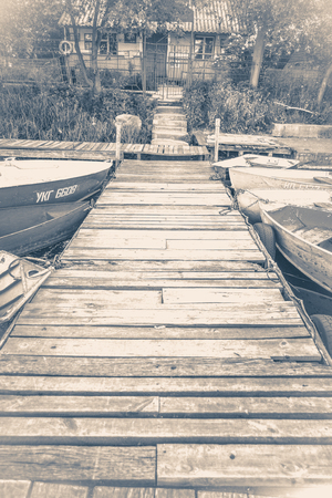 Old vintage photo. Old wooden pier and several boatsの写真素材