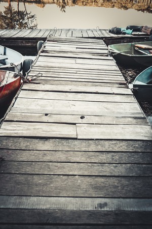 Wooden old berth. There are several boats on the dock. Sunny warm dayの写真素材
