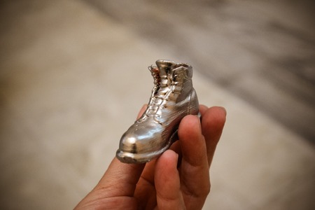 Object in the form of a boot printed on a 3d printer and covered with enamel on hand close-up. Progressive modern additive technology. Copy spaseの写真素材