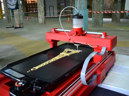 3d printer for liquid test. 3D printer printing pancakes with liquid dough different shapes close-up.の写真素材