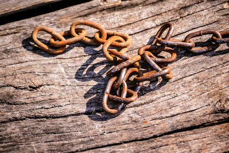 Rusty iron chain on a wooden background. Copy spase, space for text.の写真素材