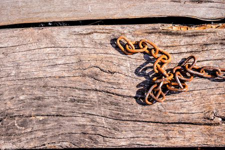 Rusty iron chain on a wooden background. Copy spase, space for text.の写真素材