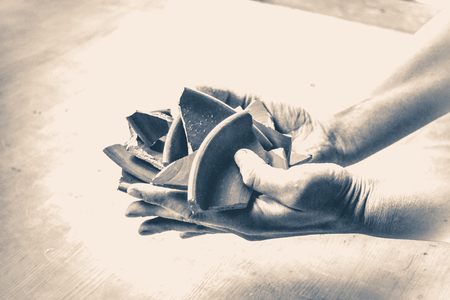 In hand debris or smithereens. Ware splinters in hands closeup. Caucasian man holds in the hands of...
