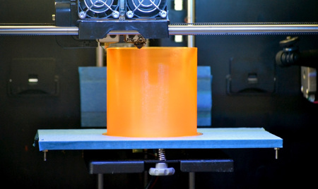 3D printer prints the form of molten plastic orange close-up. Automatic three dimensional 3d printer performs plastic modeling in laboratory. Progressive modern additive technologyの写真素材