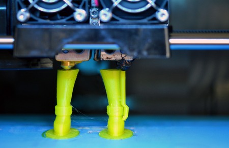 3D printer prints the form of molten plastic green close-up. Automatic three dimensional 3d printer...