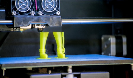 3D printer prints the form of molten plastic green close-up. Automatic three dimensional 3d printer performs plastic modeling in laboratory. Progressive modern additive technologyの写真素材