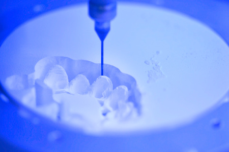 Dental milling machine carving out shape of human teeth close-up. Modern medical technologies. Concept of 4.0 industrial revolutionの写真素材