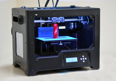 3D printer works and creates an object from the hot molten plastic close-up. Progressive modern...