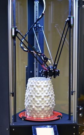 3d the printer creates a figure in the form of a white vase close-up. Progressive modern additive...