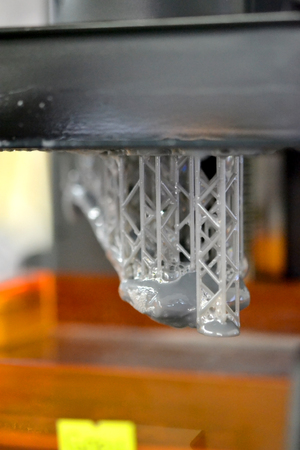 Stereolithography DPL 3d printer create detail and liquid drips, platform slowly move with liquid...