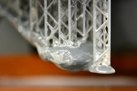 Stereolithography DPL 3d printer create detail and liquid drips, platform slowly move with liquid...