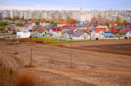 plowed field and brown house, building on a cloudy day in Ukraineの写真素材