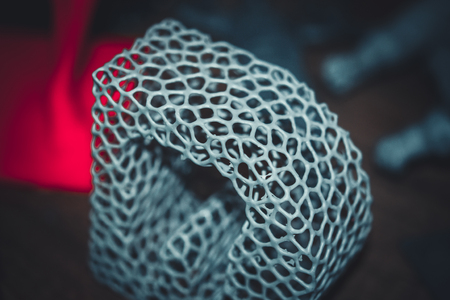 Abstract object of a gray color printed on a 3d printer on black dark surface. Fused deposition...