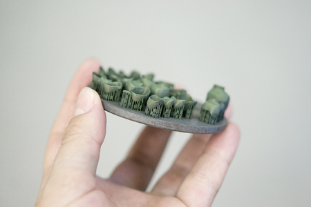 Man holding object printed on metal 3d printer after heat treatment synterization close-up. Dental...