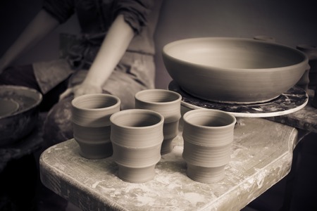 Ceramic clay products stand on the shelf close-up. Sculptor sculpts pots products from white clay. Workshop pottery. Master crock. Creativity. Cultural traditions. Handmade. Craftの写真素材