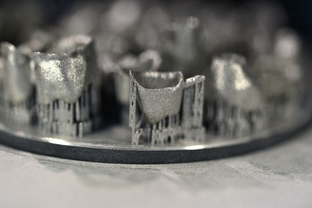 Object printed on metal 3d printer, laser sintering machine for metal close-up. A metal object sprinkled with metal powder after raising the platform into working chamber. DMLS, SLM, SLS additiveの写真素材