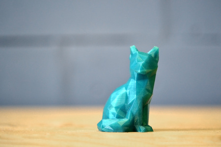 The object of green color printed 3d printer is stands on yellow table on background of gray blue brick wall close-up. Concept progressive modern additive technology for 3d printing.の写真素材