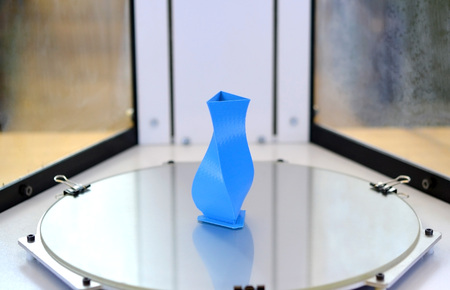 3D printer close up. Bright blue object printed by 3d printer. Modern 3D printer printing an object from the hot molten. Concept progressive additive technology for 3d printing.の写真素材