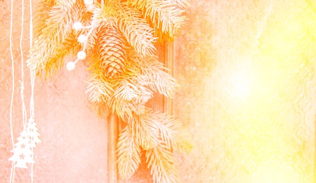 Natural Christmas New Years toy pine cone and Christmas tree branch with red yellow spot close-up....