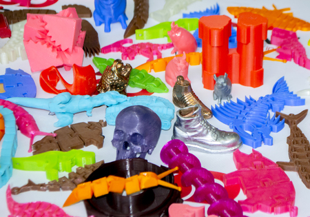 Models printed by 3d printer. Bright colorful objects printed on a 3d printer on a table close-up....