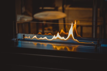 Biofireplace burn on ethanol gas. Contemporary mount biofuel on ethanol fireplot fireplace close-up. Modern smart ecological alternative technologies. Interior design of a house insideの写真素材