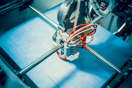 Work 3d printer close. Printing 3D printer Object Orange plastic On blue background. Plastic Wire Filament, Modern printing technology. Progressive additive technologyの写真素材