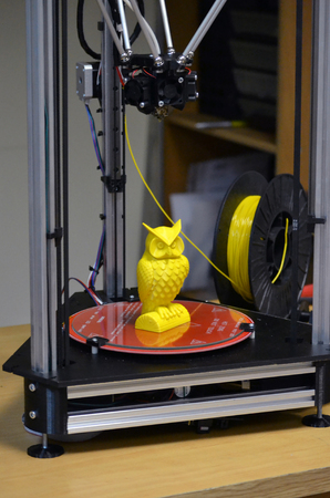 Modern 3D printer printing figure close-up. Automatic three dimensional 3d printer performs plastic yellow colors modeling in laboratory. Progressive modern additive technologyの写真素材