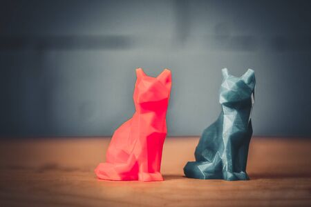 Two object of green yellow color printed 3d printer is stands on yellow table on background of gray blue brick wall close-up. Concept progressive modern additive technology for 3d printing.の写真素材