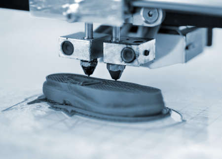 3D printer prints the form of molten plastic blue close-up