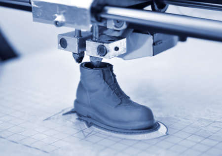 3D printer prints the form of molten plastic blue close-up.